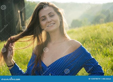 De Mooie Jonge Vrouw Lacht In Het Zonlicht Op Een Weidewi Stock Foto