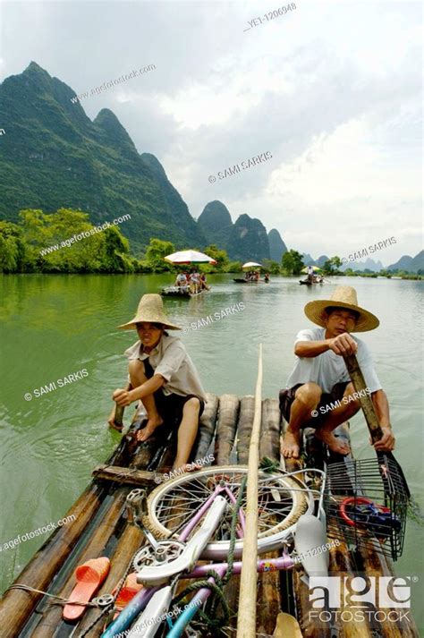 Chinese Couple Transporting Tourists Along The Yulong River On A Bamboo