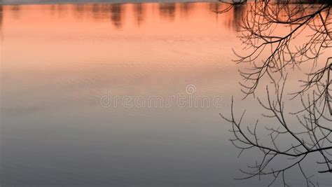Red Sunset Over The Water Of A Village Lake Stock Photo