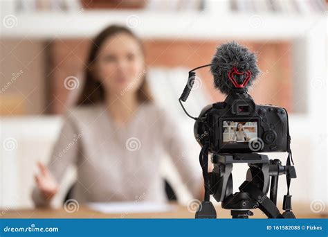 Woman Seated In Front Of Camera Filming Educational Video Stock Photo