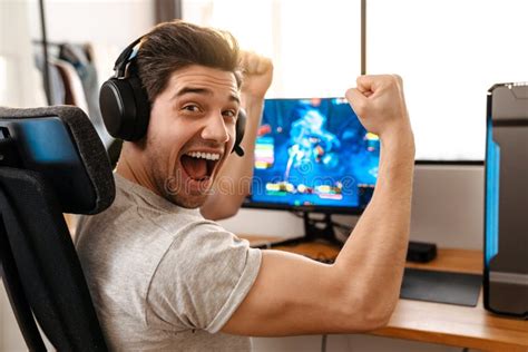 Excited Guy Making Winner Gesture While Playing Video Game On Computer