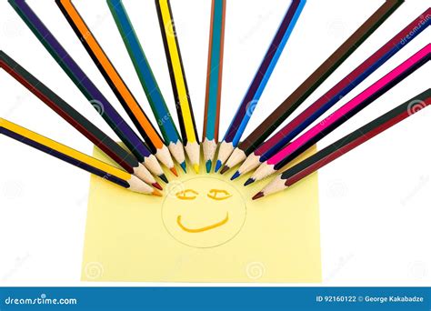A Smiley From Colored Pencils And A Yellow Sticker With A Painted Face