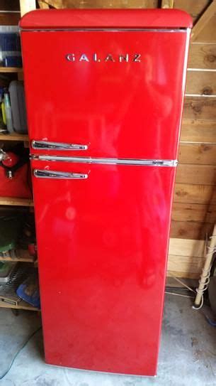An Old Red Refrigerator In A Garage