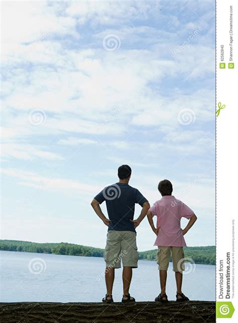 Padre E Hijo Que Miran El Lago Foto De Archivo Imagen De Parque