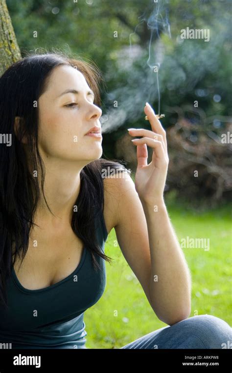 Woman Smoking A Roll Up Cigarette Outside In Garden Stock Photo