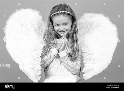 Beautiful little angel girl standing with your arms close to your chest