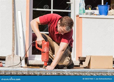 Man Drilling Hole In Wall Stock Photography 106994462
