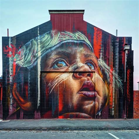 A Large Mural On The Side Of A Building With A Man S Face Painted On It