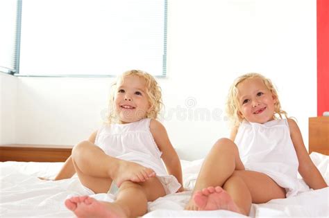 Małe Dziewczynki Siedzi Na łóżku Z Cyfrową Pastylką Obraz Stock Obraz