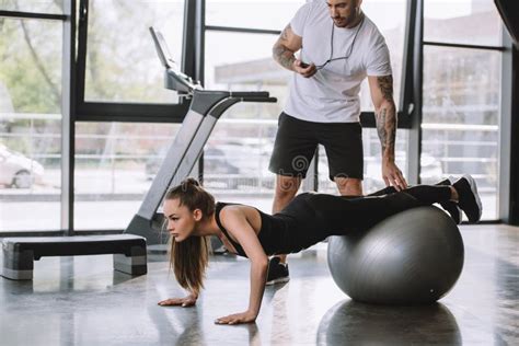Male Personal Trainer With Timer And Young Athletic Woman Stock Image