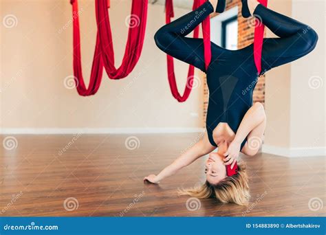 Blonde Woman Practices Inversion Anti Gravity Yoga Position Hanging