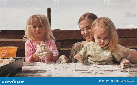 Two Daughters Knead The Dough With Their Hands Next To Their Mother Homemade Bread Baking