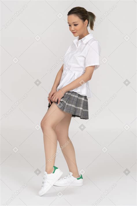 Cheerful Asian Young Woman Lifting Her Skirt Up Photo