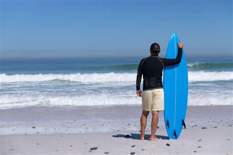 Senior Caucasian Man Holding A Surfboard At The Beach Stock Photo
