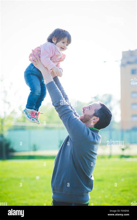 Mid Adult Man Lifting Up Toddler Daughter In Park Stock Photo Alamy