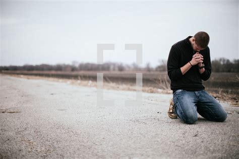 Stock Photo Man Kneeling In Prayer In The Middle Of A Road By Pearl