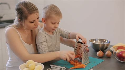 Mom Teaches Son To Rub Carrot A Young Beautiful Mother With In White