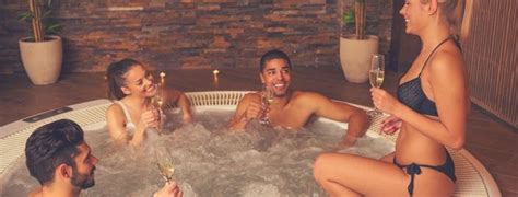 Four People In A Hot Tub With Champagne