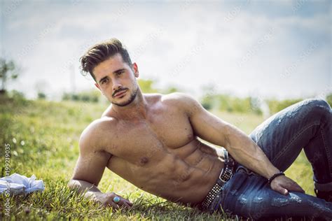 Good Looking Shirtless Fit Male Model Relaxing Lying On The Grass