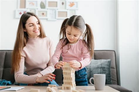 Premium Photo Mom And Daughter Play A Board Game In The Living Room