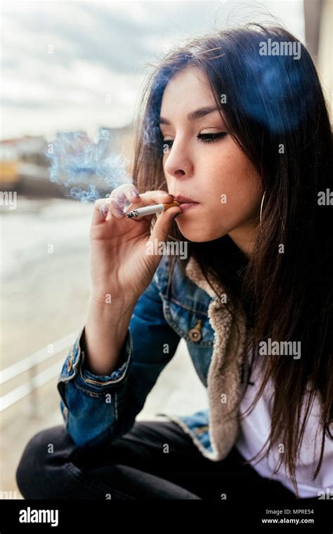 Young Woman Smoking A Cigarette Outdoors Stock Photo Alamy