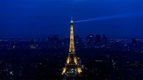 Paris Eiffel Tower With Blue Light On Top With Blue Sky Background