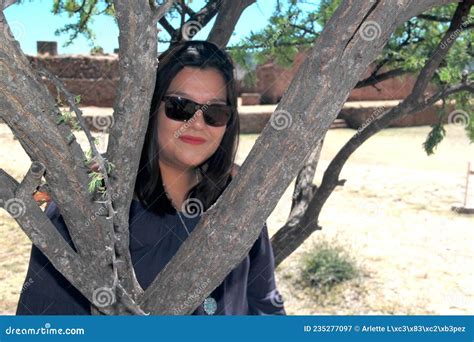 En Fullvuxen Kvinna Med Solglasögon Som Sitter På Ett Träd Ser Sitt