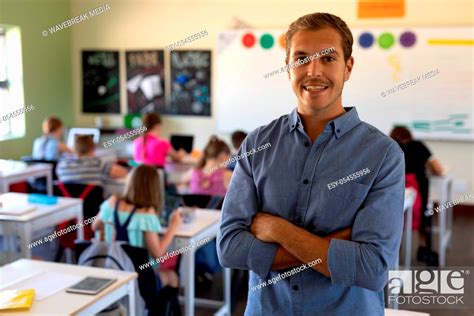 Portrait Of A Caucasian Male School Teacher Standing With Arms Crossed