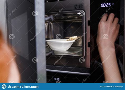 Woman Heats Food In The Microwave Kitchen Appliances Built Into
