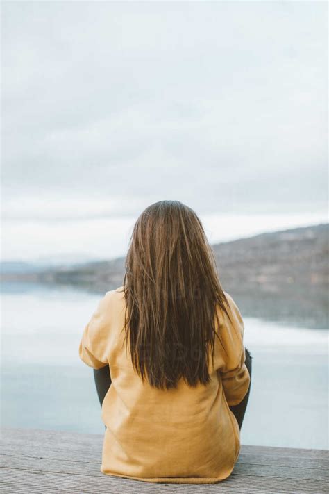 Back View Of Young Woman Sitting On Jetty Ocaf00205 Oriol Castelló