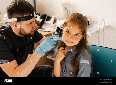 Ent Doctor Otolaryngologist Looks Through Otoscope The Ears Of A Little