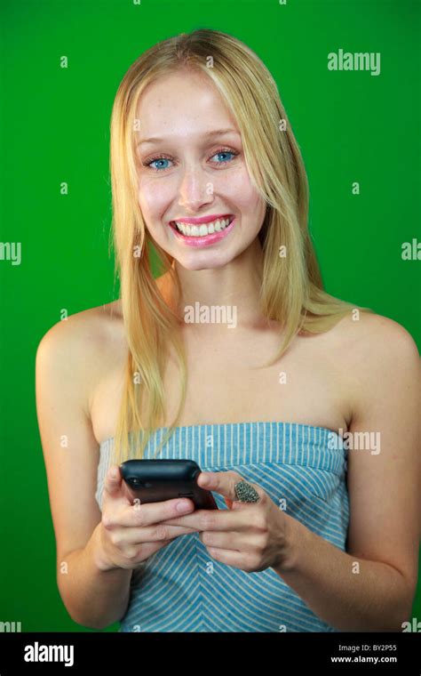 Blond Caucasian Young Woman In Front Of Green Screen Using Apps