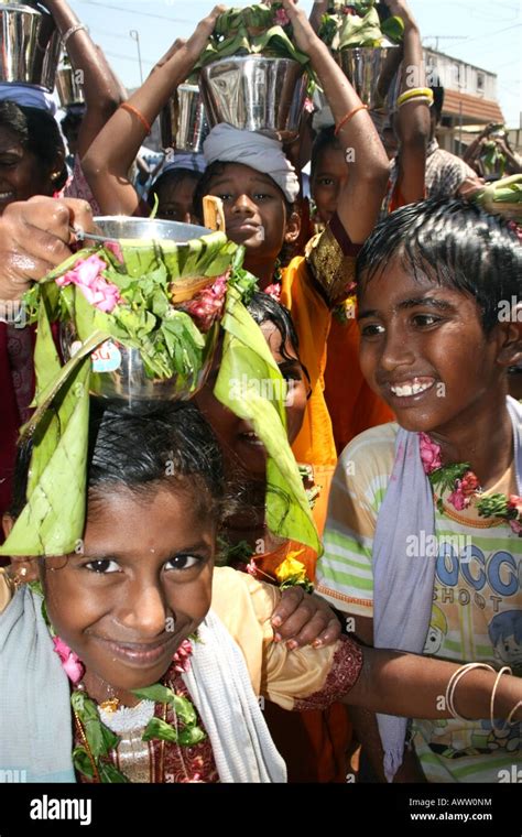 Los niños de la aldea llevar metal tumeric olla de agua y desde el agua