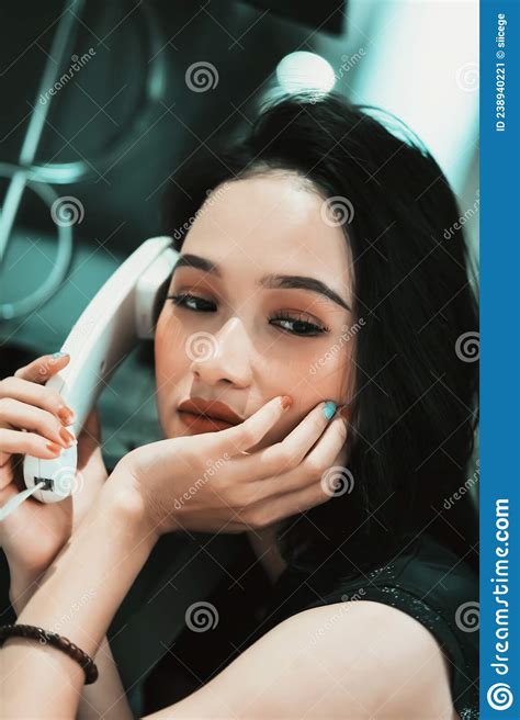 Asian Women Make A Phone Call While Wearing A Black Dress And Bracelet