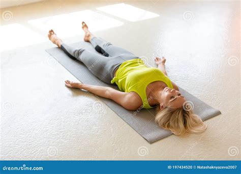 Fit Adult Woman Lying On The Mat In Shavasana And Practice Yoga Nidra