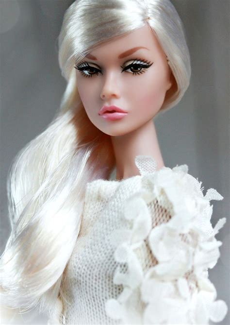A Doll With Long Blonde Hair Wearing A White Dress