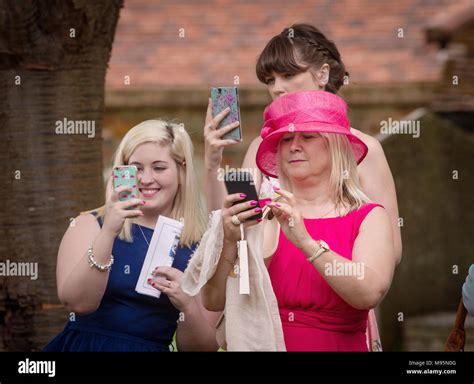 Female Guests At Wedding Taking Photographs On Mobile Phones Stock