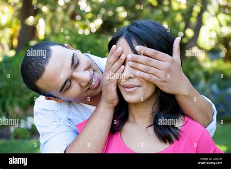 Man Covering Eyes Of Woman With His Hand Surprise Hi Res Stock