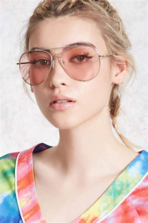a pair of aviator sunglasses featuring neon tinted lenses high polish frames and a brow bar