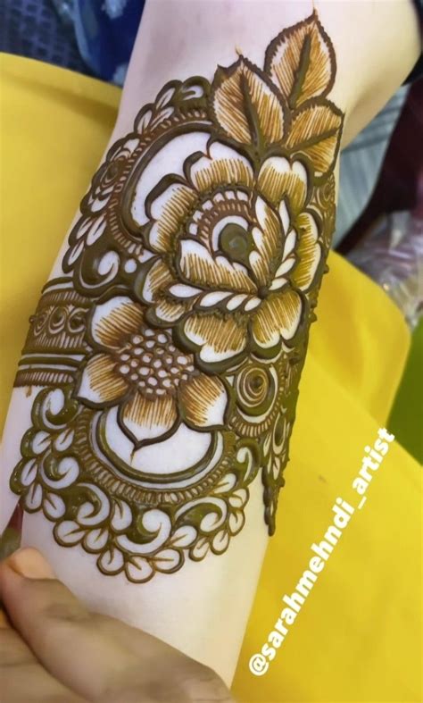 A Womans Arm With Henna Tattoos On It And Flowers In The Middle