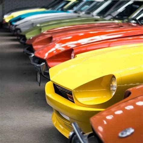 Many Different Colored Cars Are Lined Up In A Row And One Is Orange