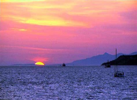 Pink Sunset Over The Ocean With Mountains And Boats Pink