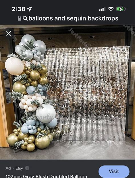 A Christmas Tree Made Out Of Balloons In Front Of A Mirrored Wall With Silver And Gold Ornaments