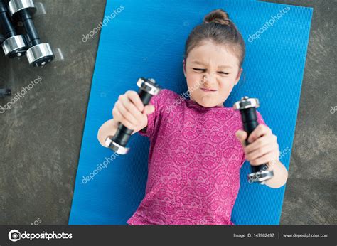 Girl Exercising With Dumbbells — Stock Photo © Natashafedorova 147982497