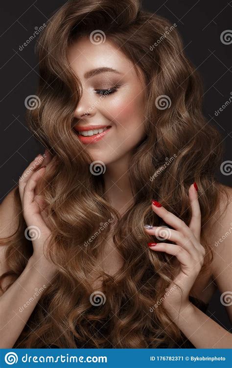 Beautiful Brown Haired Girl With A Perfectly Curls Hair And Classic Make Up Beauty Face And