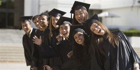 A Group Of People In Graduation Gowns Posing For A Photo Together With