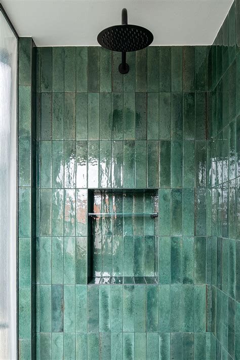 A Green Tiled Bathroom With A Shower Head