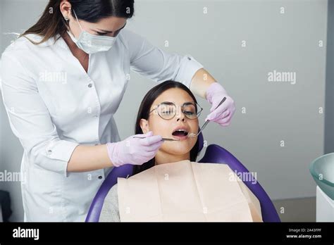 A Woman Is Preparing For A Dental Examination Woman Having Teeth Examined At Dentists Stock