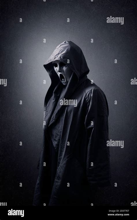 Scary Figure With Mask In Hooded Cloak In The Dark Stock Photo Alamy