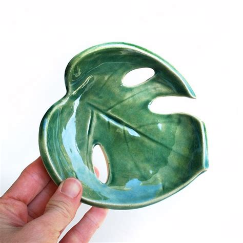 A Hand Holding A Green Leaf Shaped Bowl